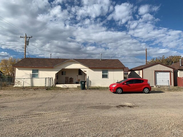 ranch-style house with a detached garage and fence