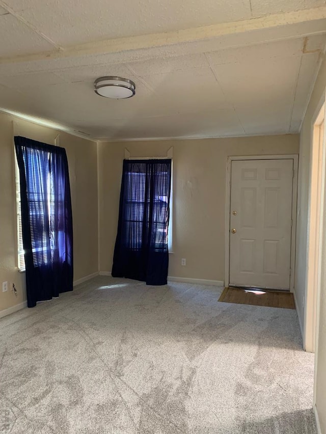 foyer featuring carpet and baseboards