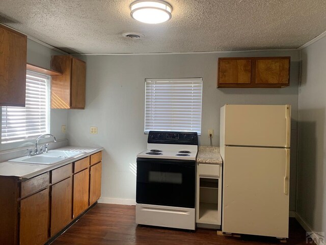 kitchen with a sink, light countertops, electric stove, and freestanding refrigerator