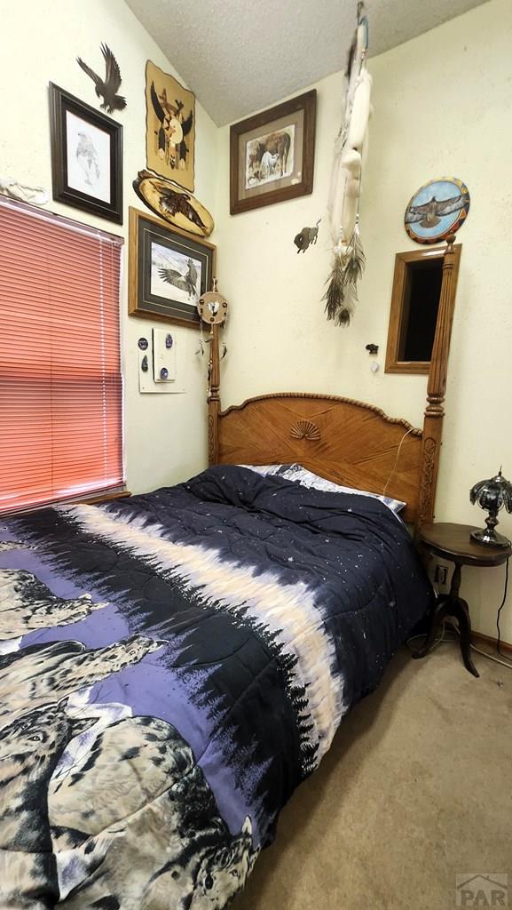 997 Wells Fargo Cir, Jefferson, CO 80456 - bedroom featuring carpet floors, a textured ceiling, and lofted ceiling