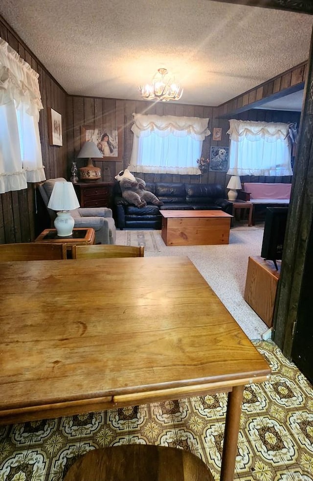 997 Wells Fargo Cir, Jefferson, CO 80456 - dining room with a textured ceiling, wood walls, a chandelier, and carpet flooring