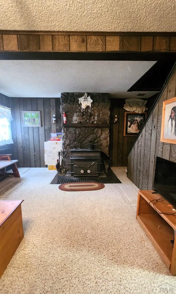 997 Wells Fargo Cir, Jefferson, CO 80456 - living room with a fireplace, wooden walls, and carpet flooring