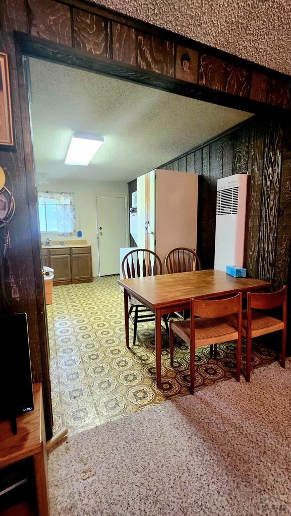 997 Wells Fargo Cir, Jefferson, CO 80456 - dining area with tile patterned floors, a heating unit, and a textured ceiling