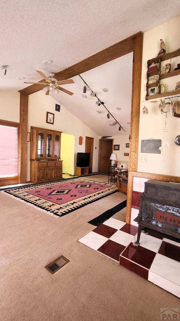 997 Wells Fargo Cir, Jefferson, CO 80456 - carpeted living area featuring track lighting, lofted ceiling, a ceiling fan, and a textured ceiling
