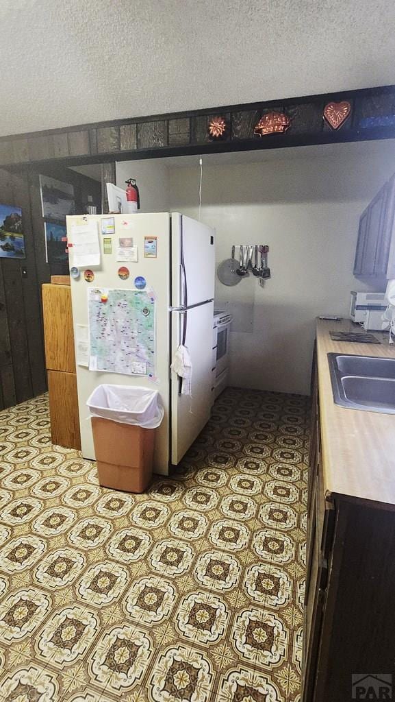 997 Wells Fargo Cir, Jefferson, CO 80456 - kitchen featuring freestanding refrigerator, tile patterned floors, a textured ceiling, light countertops, and oven