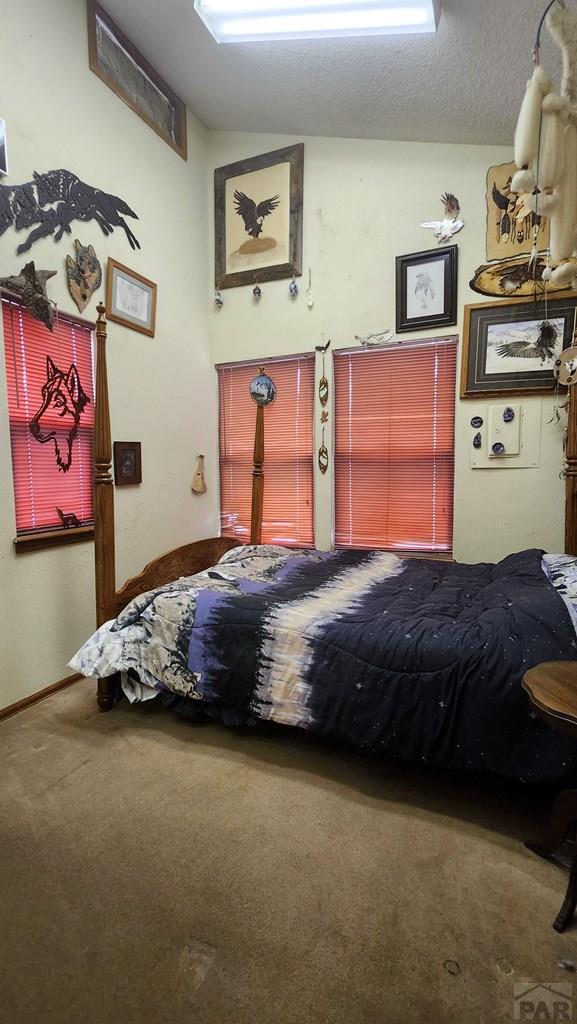 997 Wells Fargo Cir, Jefferson, CO 80456 - carpeted bedroom featuring vaulted ceiling