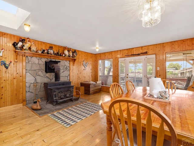 1505 Center Ln, Pueblo, CO 81006 - dining space featuring plenty of natural light, a wood stove, wooden walls, a skylight, and hardwood / wood-style flooring