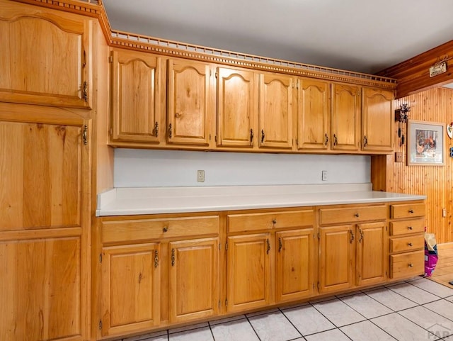 1505 Center Ln, Pueblo, CO 81006 - kitchen featuring light tile patterned flooring, light countertops, wood walls, and brown cabinets