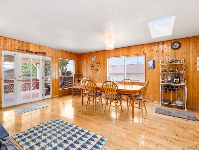 1505 Center Ln, Pueblo, CO 81006 - dining room featuring wooden walls, hardwood / wood-style floors, a skylight, and a chandelier