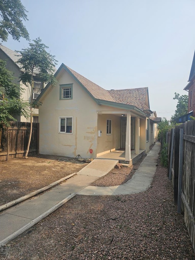 exterior space featuring a fenced backyard, a patio, a shingled roof, and stucco siding