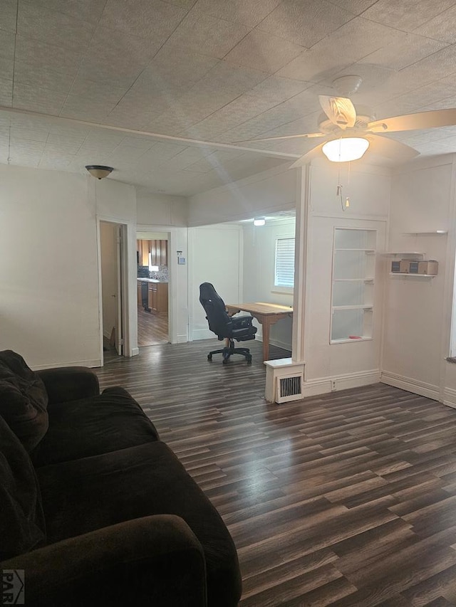 living area with dark wood-style floors, visible vents, and baseboards