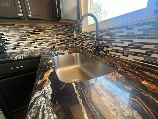 room details featuring decorative backsplash, a sink, dark stone countertops, and dark brown cabinets