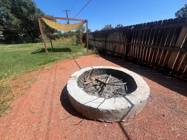 view of yard with a fire pit and fence