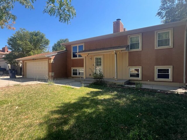 view of front of house featuring driveway, a chimney, an attached garage, a front yard, and stucco siding