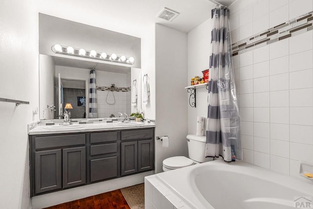 4141 Outlook Blvd Unit Q, Pueblo, CO 81008 - full bath featuring tiled tub, double vanity, curtained shower, and wood finished floors