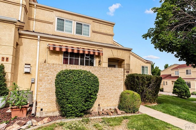 4141 Outlook Blvd Unit Q, Pueblo, CO 81008 - view of front of property with stucco siding and a front yard