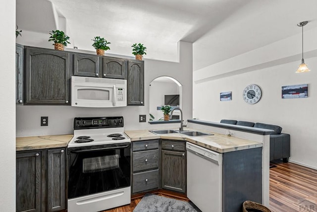 4141 Outlook Blvd Unit Q, Pueblo, CO 81008 - kitchen with white appliances, a peninsula, light countertops, and dark wood finished floors