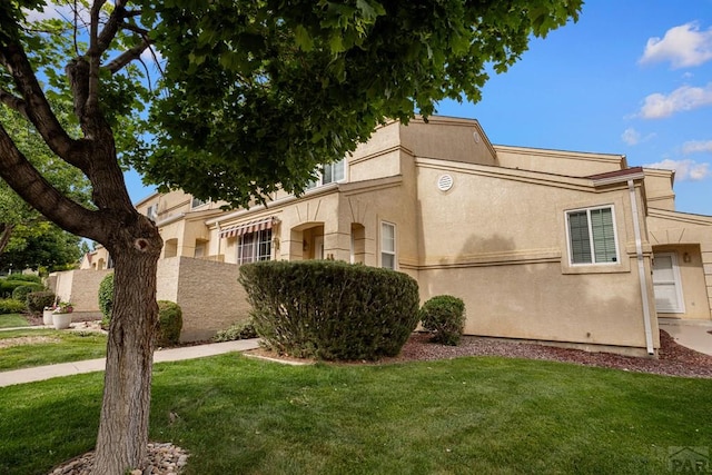 4141 Outlook Blvd Unit Q, Pueblo, CO 81008 - view of side of property featuring a lawn and stucco siding