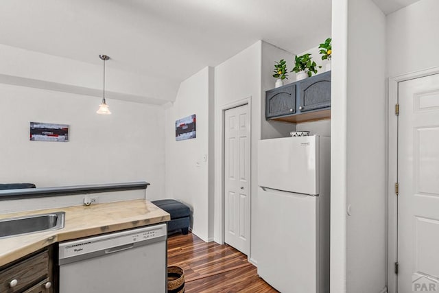 4141 Outlook Blvd Unit Q, Pueblo, CO 81008 - kitchen with freestanding refrigerator, dishwasher, dark wood-style floors, light countertops, and decorative light fixtures