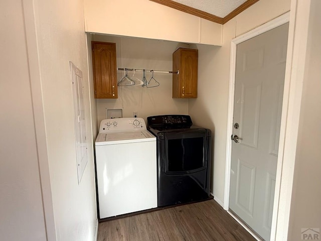 laundry room with dark wood finished floors, separate washer and dryer, crown molding, and cabinet space