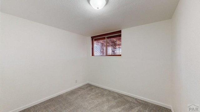 unfurnished room with carpet, a textured ceiling, and baseboards