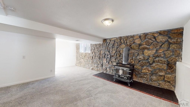 living area with a wood stove and carpet floors