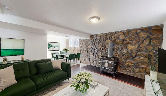 living room with a wood stove and wood finished floors