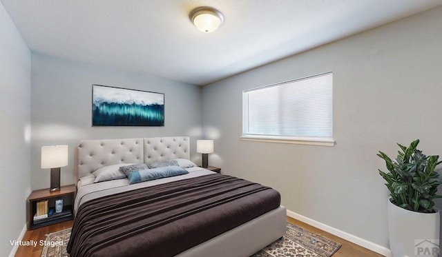 bedroom with baseboards and wood finished floors