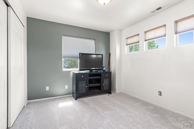 unfurnished bedroom with baseboards, carpet, a closet, and visible vents