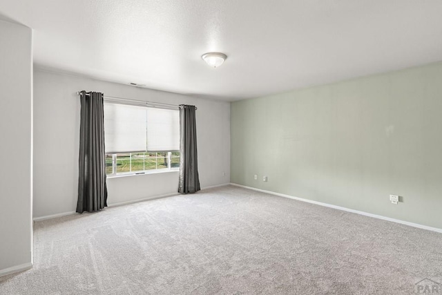 empty room featuring baseboards, carpet flooring, and visible vents