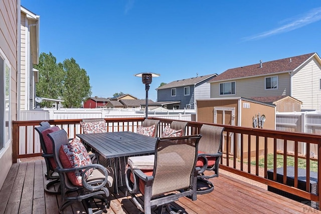 wooden deck with a fenced backyard, a residential view, and outdoor dining space