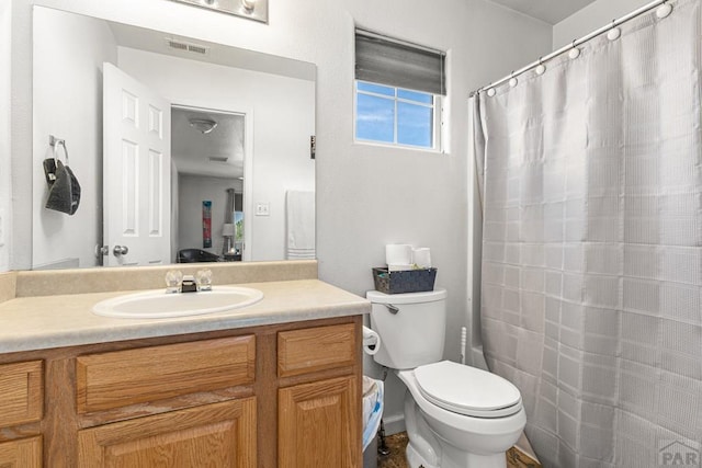 bathroom with visible vents, a shower with shower curtain, toilet, and vanity