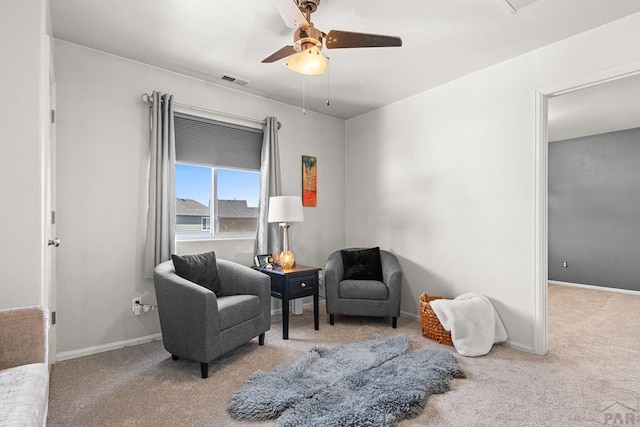 sitting room with carpet floors, ceiling fan, baseboards, and visible vents