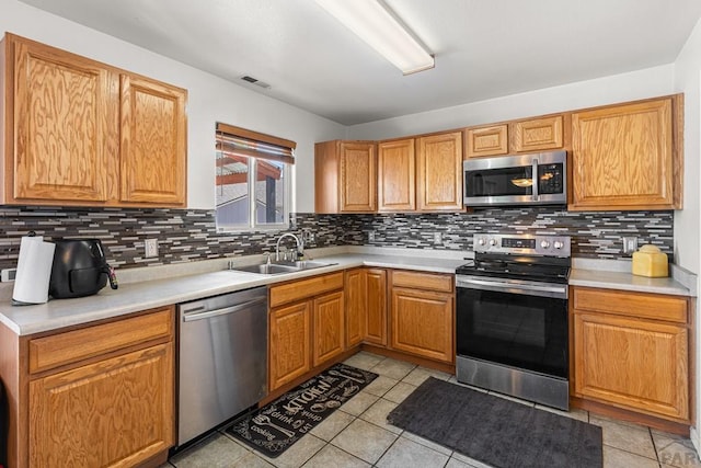 kitchen featuring stainless steel appliances, visible vents, a sink, and tasteful backsplash