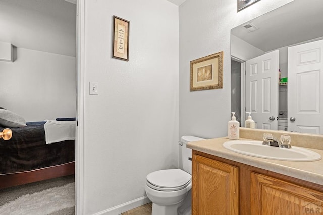 ensuite bathroom featuring vanity, ensuite bath, visible vents, and toilet