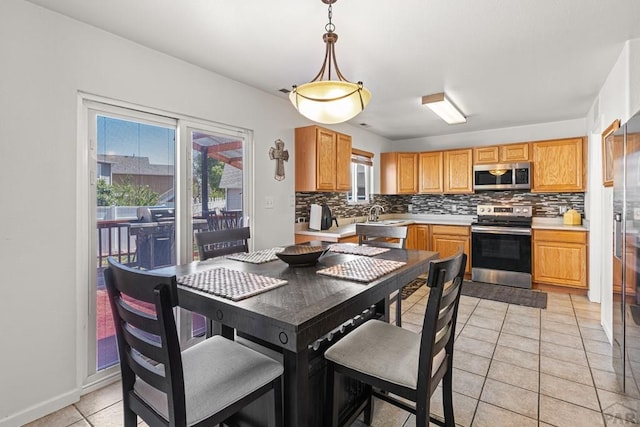 dining space with light tile patterned floors, baseboards, and a wealth of natural light