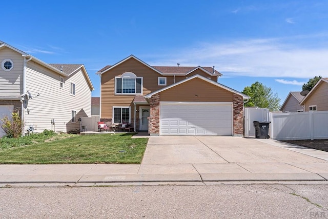 traditional-style home with a garage, fence, driveway, and a front yard