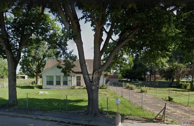 view of front of house featuring fence and a front lawn