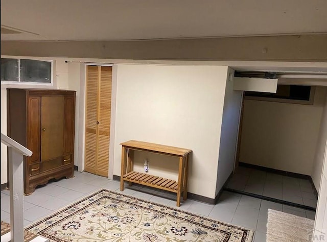 hall featuring light tile patterned floors and baseboards