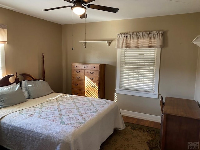 bedroom featuring ceiling fan, baseboards, and wood finished floors