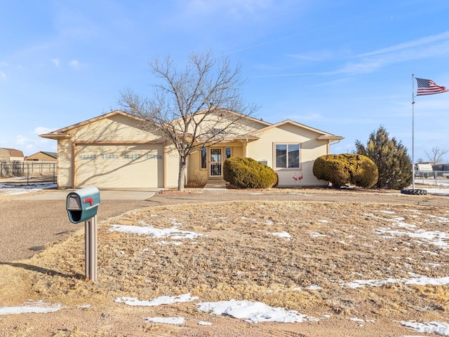 ranch-style home with a garage, fence, and concrete driveway