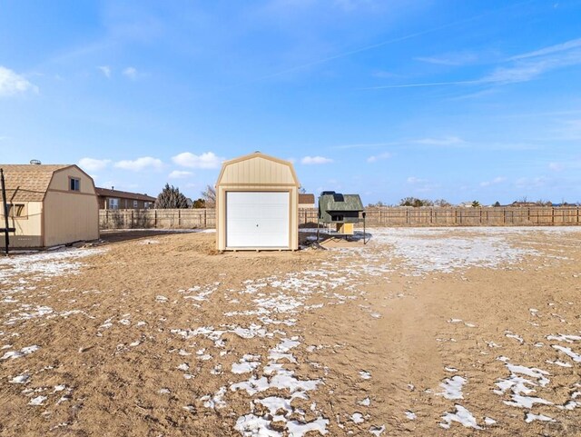 view of yard featuring fence, a storage unit, and an outbuilding