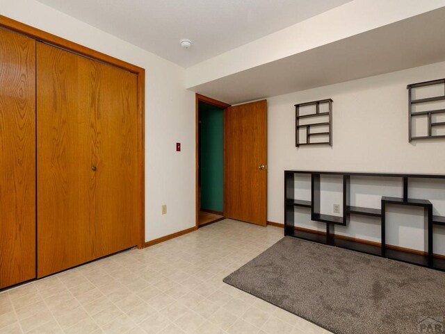 interior space featuring light floors and baseboards