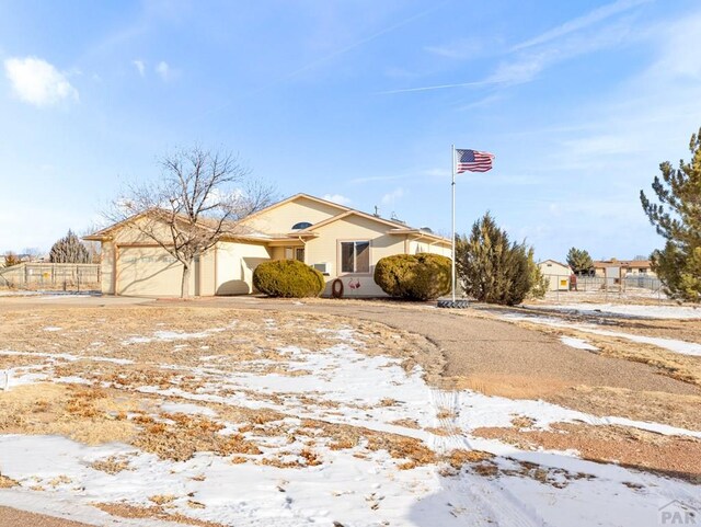 view of front of house with a garage, driveway, and fence