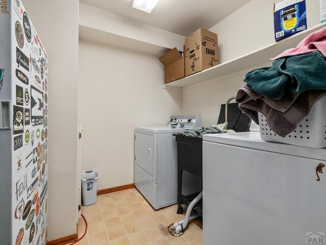 laundry area featuring washer and dryer, laundry area, and baseboards