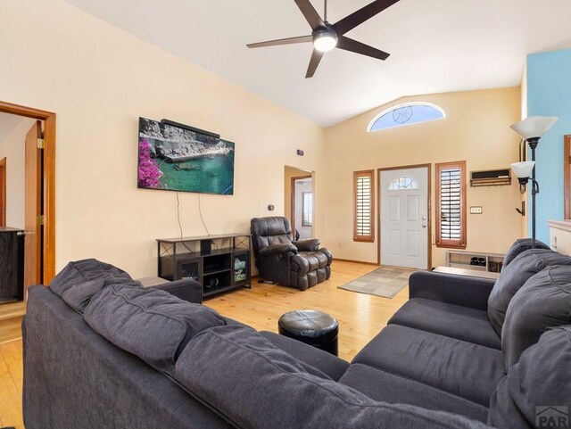 living room with lofted ceiling, ceiling fan, and light wood finished floors