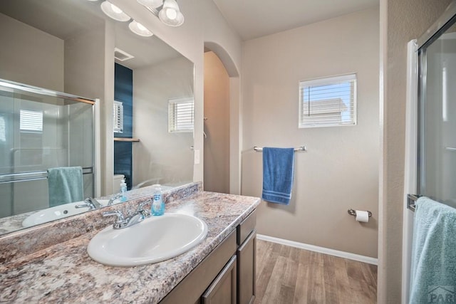 2337 Cruz Ct, Pueblo, CO 81003 - full bathroom featuring wood finished floors, a shower stall, baseboards, vanity, and toilet