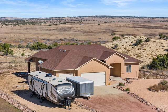 view of front of home featuring concrete driveway, an attached garage, and stucco siding