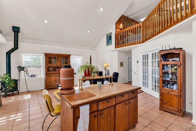 kitchen with tile counters, french doors, brown cabinetry, and light tile patterned floors