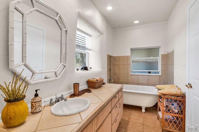 bathroom with a soaking tub, tile patterned flooring, vanity, and recessed lighting